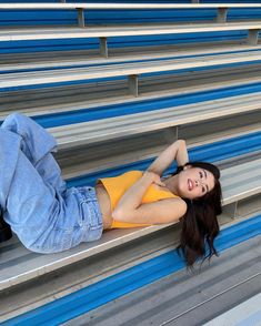 a woman laying on the bleachers with her legs crossed