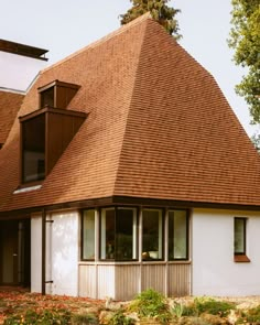 a small white house with a brown roof