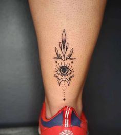 a woman's foot with a tattoo on it and an eye in the center