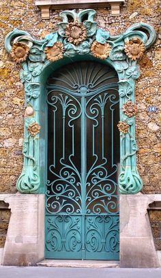 an ornately decorated door on the side of a building with stone walls and windows