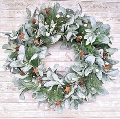 a wreath with evergreen leaves and pine cones