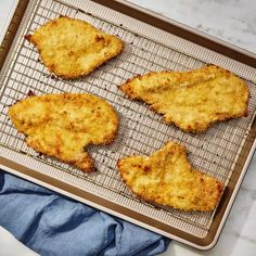 four pieces of fried chicken on a baking sheet