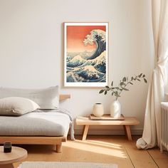 a room with a bed, coffee table and painting on the wall above it that has an ocean wave