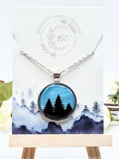 This one of a kind Round Tree pendant was handmade out of polymer clay and and sealed with resin for a durable finish. The chain is high quality stainless steel. If you have questions about this product or if you want to inquire about creating a custom order please don't hesitate to reach out! Themed Stainless Steel Jewelry As Gift, Handmade Themed Pendant Jewelry, Blue Wearable Art Necklace As Gift, Blue Wearable Art Necklace For Gift, Themed Round Pendant Jewelry As Gift, Unique Blue Necklace Gift, Themed Round Pendant Jewelry For Gifts, Hand Painted Nature-inspired Necklace For Gift, Silver Polymer Clay Pendant Necklace