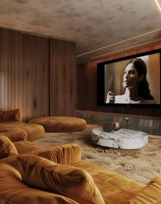 a living room with couches and a flat screen tv on the wall in front of it