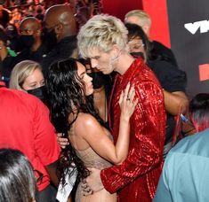 two women hugging each other in front of a group of people at a red carpet event