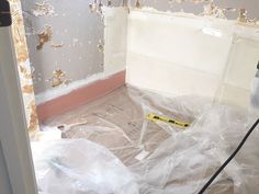 a room that is being remodeled with plastic covering the floor and walls, including a vacuum