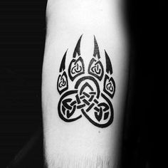 a black and white photo of a dog paw tattoo on the right leg, with an intricate design