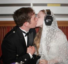 a man and woman kissing each other while wearing headphones on their headset's ears