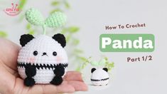 a hand holding a small crocheted panda doll next to it's face