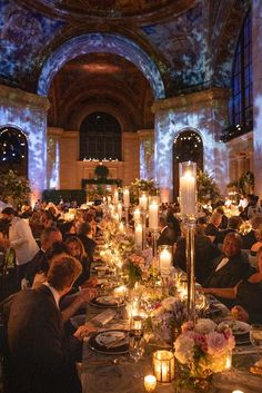 a group of people sitting at tables with candles