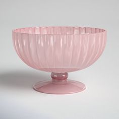 a pink glass bowl sitting on top of a table