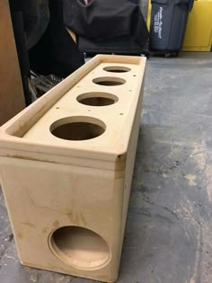 a wooden box with holes in it sitting on the ground