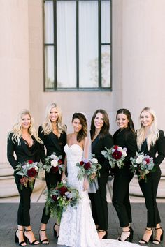 a group of women standing next to each other in front of a building with flowers