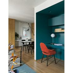 a living room filled with furniture next to a blue wall and wooden floored walls