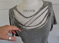 a woman is holding onto the back of her gray shirt that says stretch on it