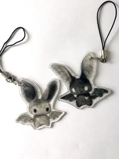 two small animal shaped pendants hanging from strings