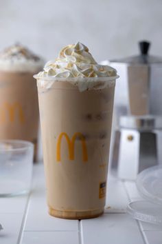 there are two drinks with whipped cream on top and one has a mcdonald's logo