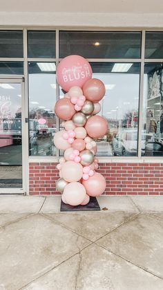 a bunch of balloons that are in front of a store window with the words blush on it