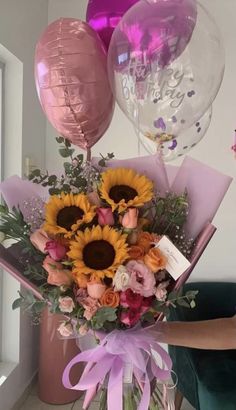 a vase filled with sunflowers and balloons