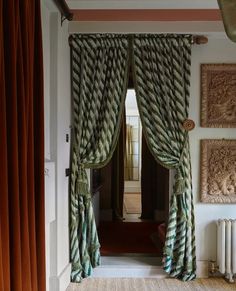 an open door with curtains and pictures on the wall