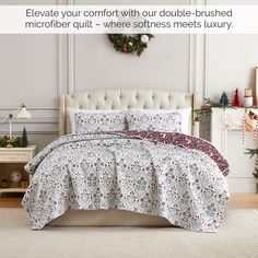 a white bed with red and green comforter next to a christmas wreath on the wall