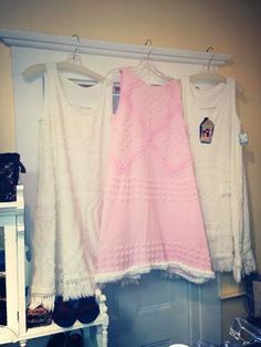 three dresses hanging on a rack in a closet