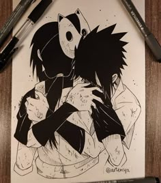 a drawing of two people hugging each other on a piece of paper with markers next to it