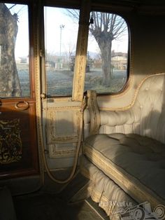 the inside of an old bus with its door open and seat up to it's side