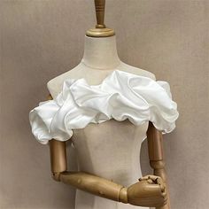 a mannequin wearing a white dress with ruffles on it's shoulders