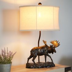 Add the perfect touch to your rustic themed room with this moose lamp. Features include a cream fabric shade and rich bronze finishes for the perfect accent piece in your family room, den, man cave, or anywhere you want to add a charming finishing touch. Litex Ozark 22-in Bronze On/Off Switch Table Lamp with Fabric Shade | LBSH033L Outdoorsy Decor, Walnut House, Craft Tables, Hunting Land, Beautiful Bedrooms Master, Bronze Table Lamp, Bronze Table, Cabin Interiors, Themed Room