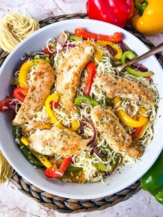 a white bowl filled with chicken scamps and peppers on top of a table