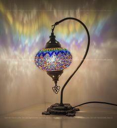 a lamp that is sitting on top of a table in front of a colorful wall