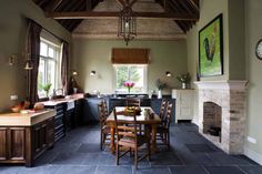 a dining room table and chairs in front of a fireplace