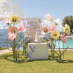 flowers and butterflies are on display in front of a pool