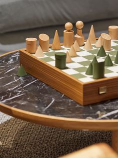 a wooden chess set sitting on top of a marble table next to a chair and couch