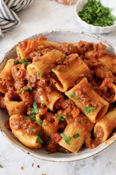 a bowl filled with pasta and meat sauce