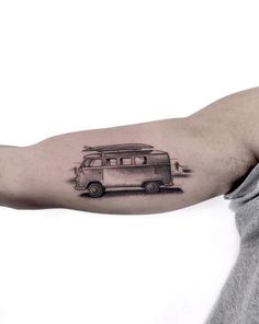 a man's arm with a small tattoo of a camper van