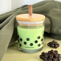 a glass jar filled with raisins sitting on top of a table next to a blanket