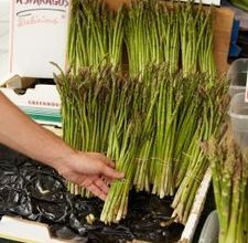 a bunch of asparagus being held by a person