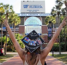 a woman wearing a graduation cap with her hands up in the air at university of florida