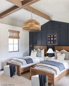 two beds in a room with blue walls and white carpeted floors, one has a wicker basket hanging from the ceiling