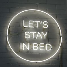 a neon sign that says let's stay in bed