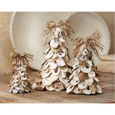 three small christmas trees made out of seashells