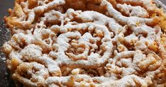 a pastry with powdered sugar on top is sitting on a black plate and looks like it has been baked