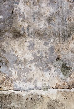 an old concrete wall with peeling paint on it