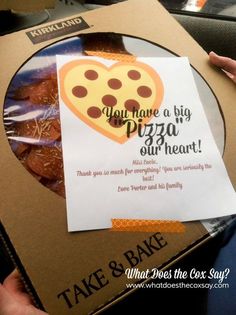 someone is holding up a pizza box with a card in it that says, you have a big pizza our heart