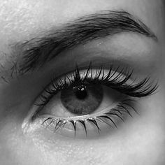 an eye with long lashes is shown in black and white