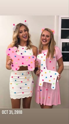 two women dressed in costumes holding up letters that spell out the word'i love you '