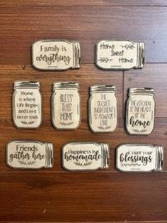 six mason jars with sayings on them sitting on top of a wooden table next to each other